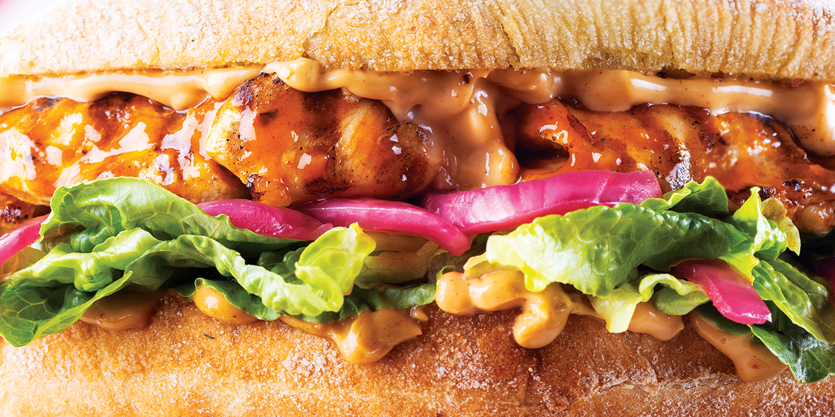a Nando’s meal on a table including PERi-PERi chicken, a salad, chips, and a selection of sides